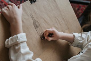 Person sketching on kraft paper — photo by olia danilevich on Pexels