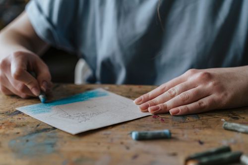 Free A child drawing a colorful picture using pastel colors on paper indoors. Stock Photo