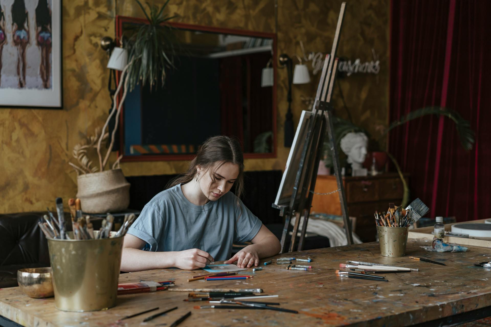 Teenage Girl in Blue Shirt Doing Art Coloring Using Crayons on a Wooden Table