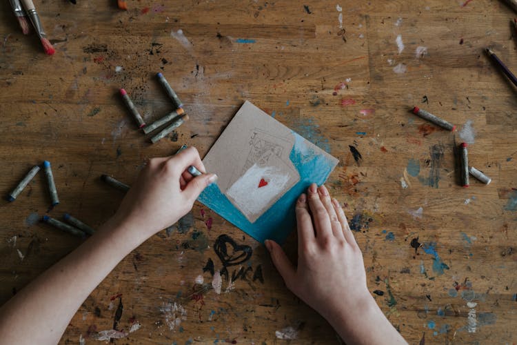 A Person Coloring A Drawing Of Playing Cards On A Paper
