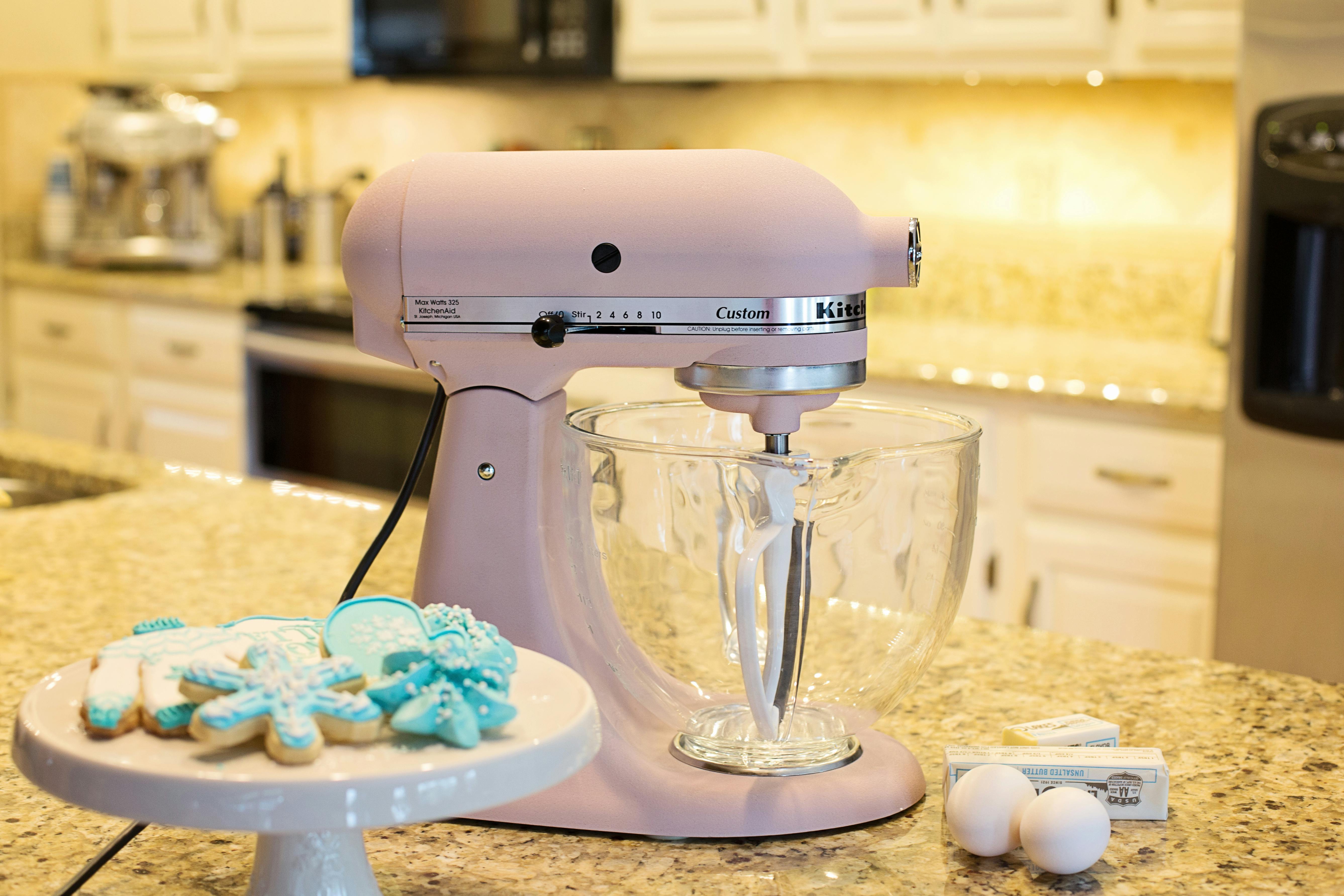 Free Pastel mixer in a modern kitchen setting, surrounded by baking essentials and decorative cookies. Stock Photo