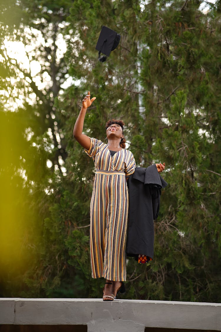 Woman Tossing Her Mortarboard After Graduating 