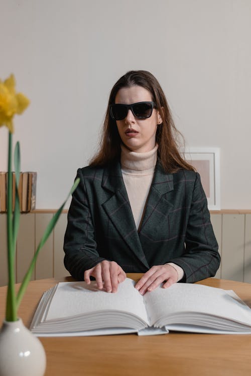 Free A Blind Woman wearing Sunglasses Reading a Braille Book Stock Photo