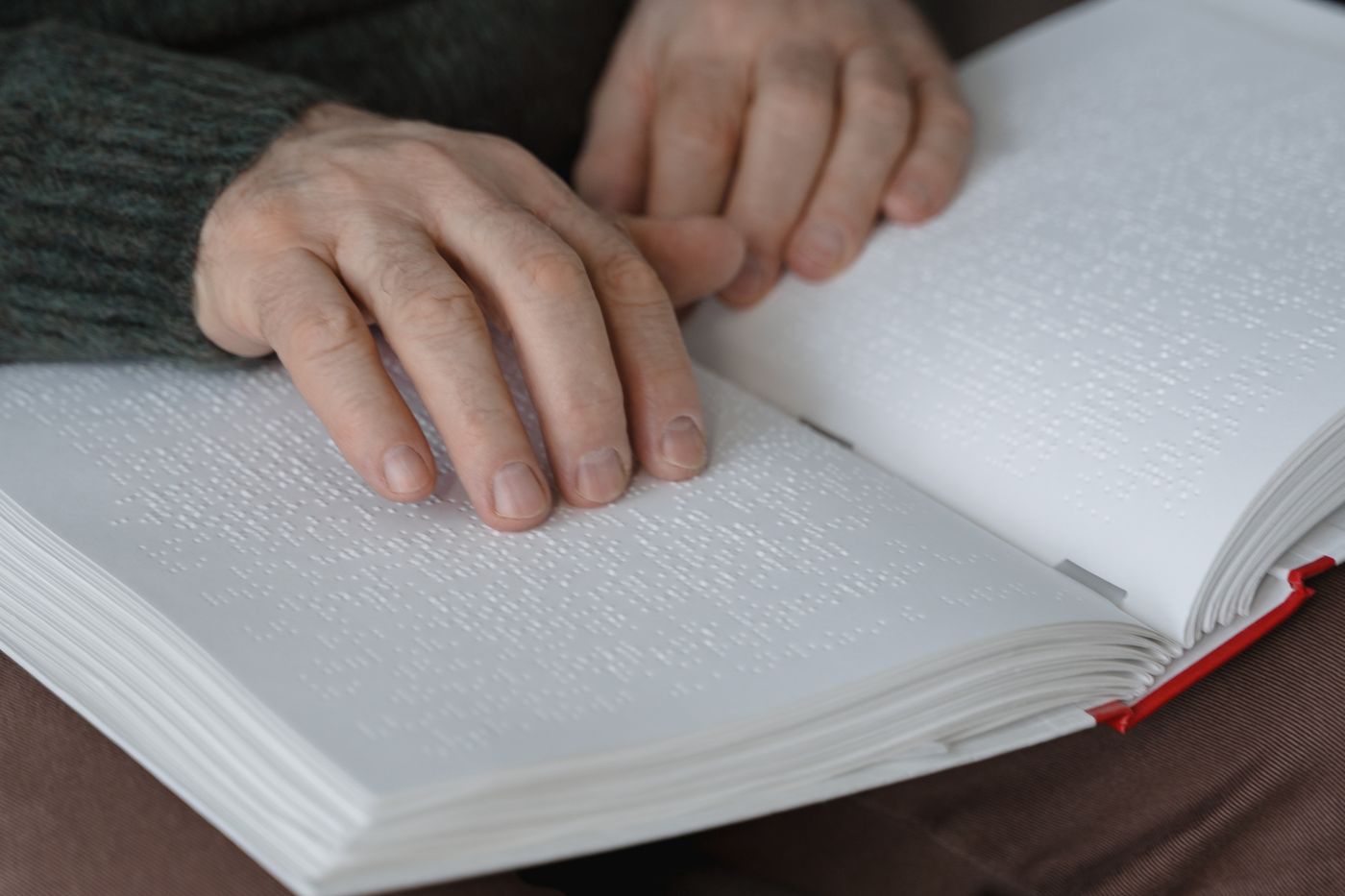 Hands reading a braille page