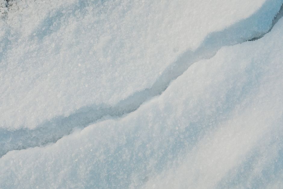 Detailed view of a cracked snow surface, showcasing winter's natural patterns.