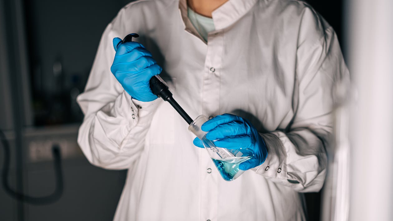Free A Person Wearing Gloves Holding Laboratory Equipment Stock Photo