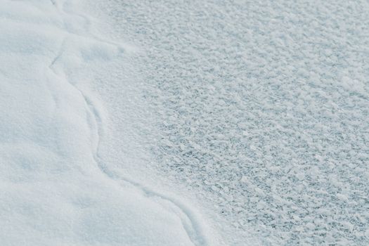 Detailed view of frosty crystallized snow with intricate patterns and textures.