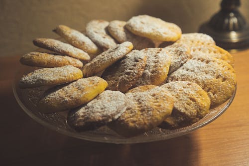 From above of delicious sweet baked cookies served on plate on wooden table