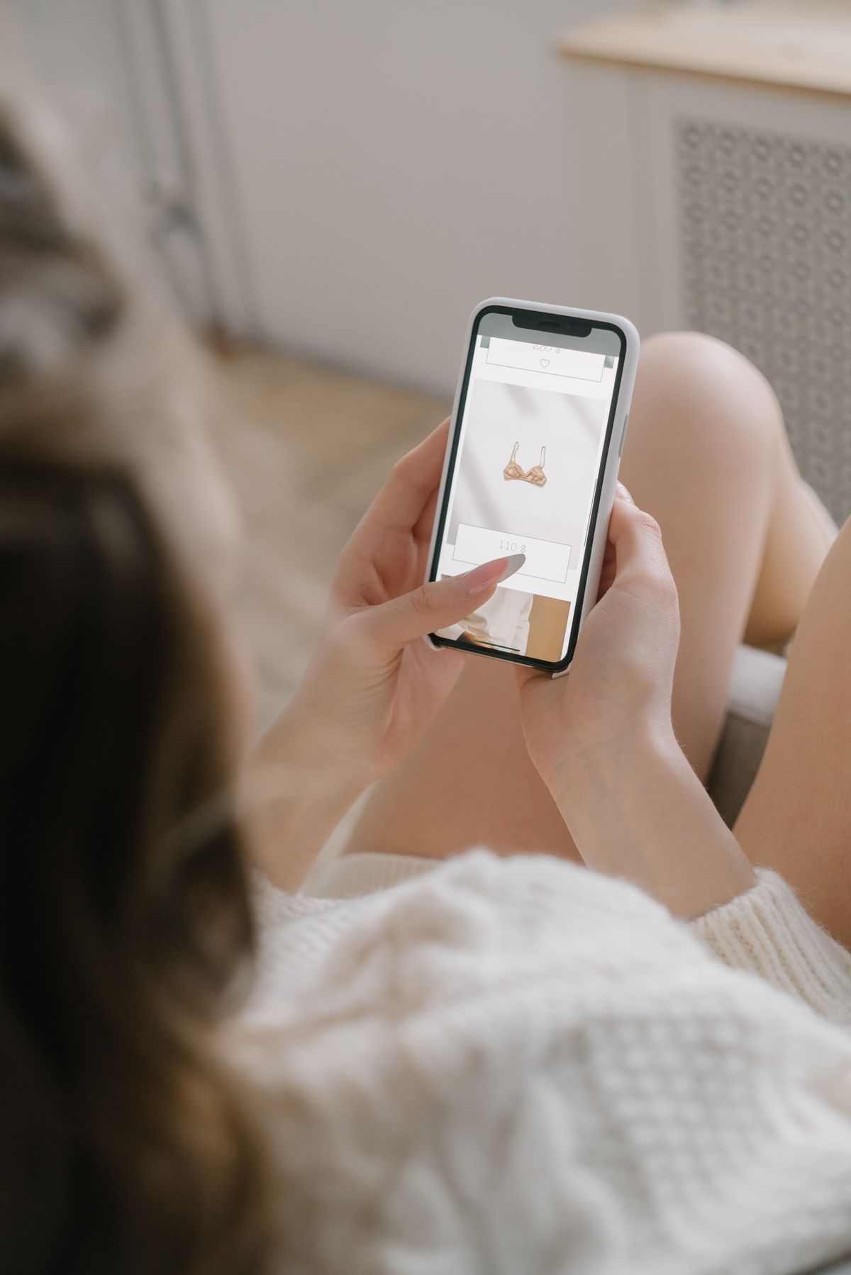 A woman browsing an online store on her smartphone at home
