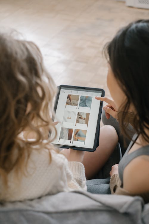 Free People Sitting Close Togehter Using an iPad Stock Photo