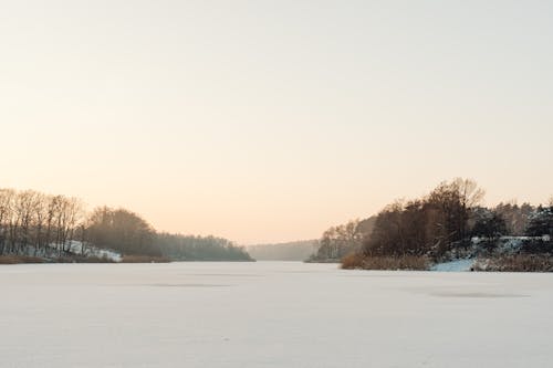 Landscape of a of a Field Covered in Snow at Sunset 