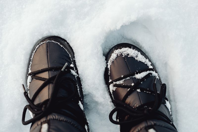 Black winter boots covered in snow
