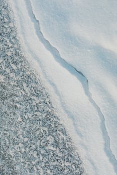 Detailed view of a snow-covered landscape featuring natural cracks and textures.