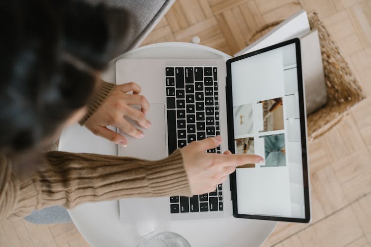 A Finger Pointing The Screen Of A Laptop