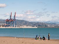 Pescadores con cañas de lance en la costa