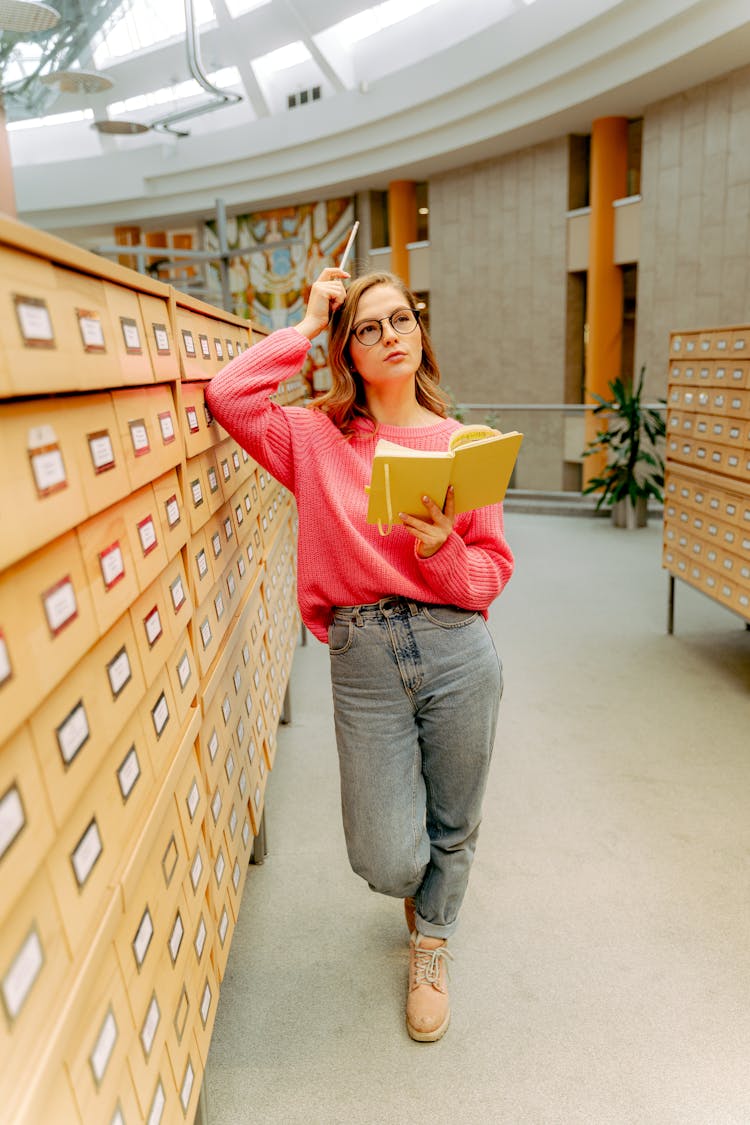 Blonde Woman In Pink Sweater In Library