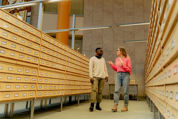 Museum staff reviewing archive storage aisle