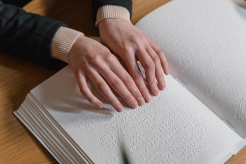 Free Close-up of hands reading Braille, symbolizing independence and accessibility for the visually impaired. Stock Photo