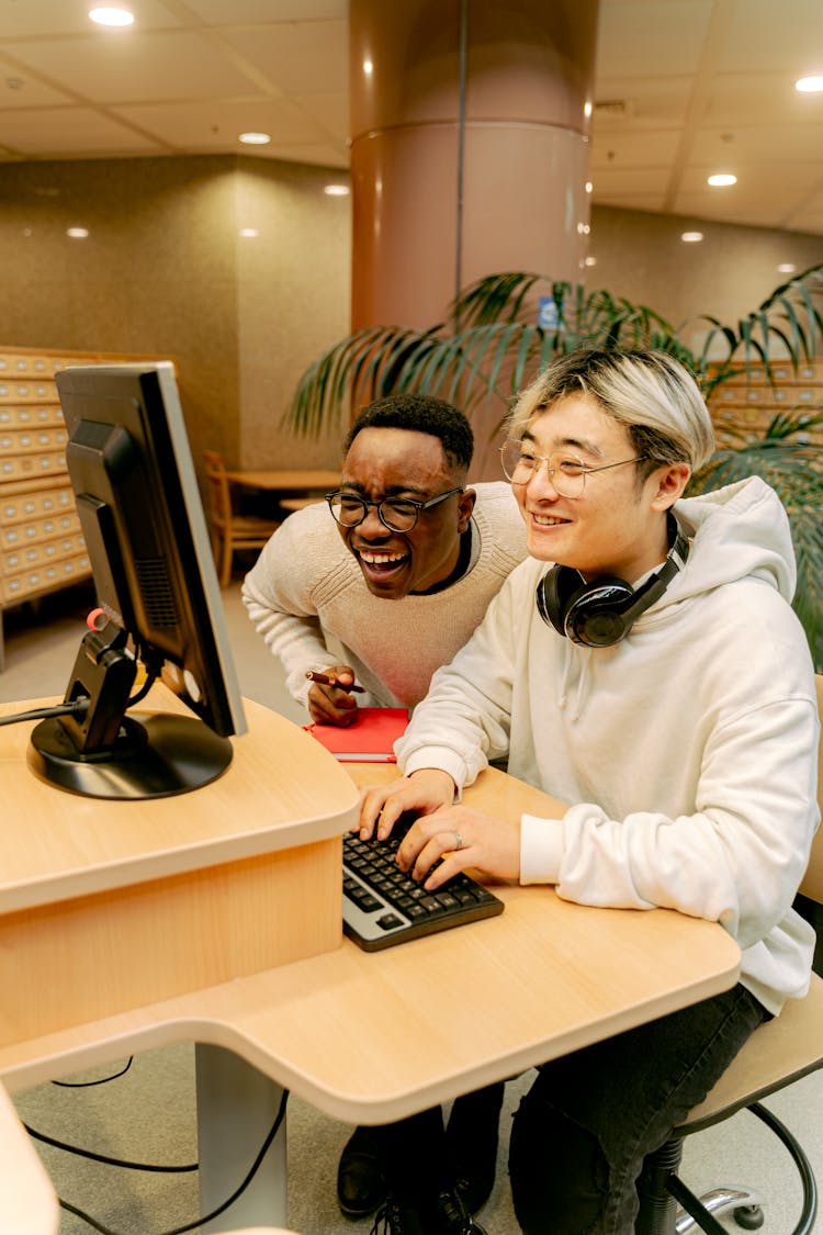 Happy Guys Working On Computer In Library