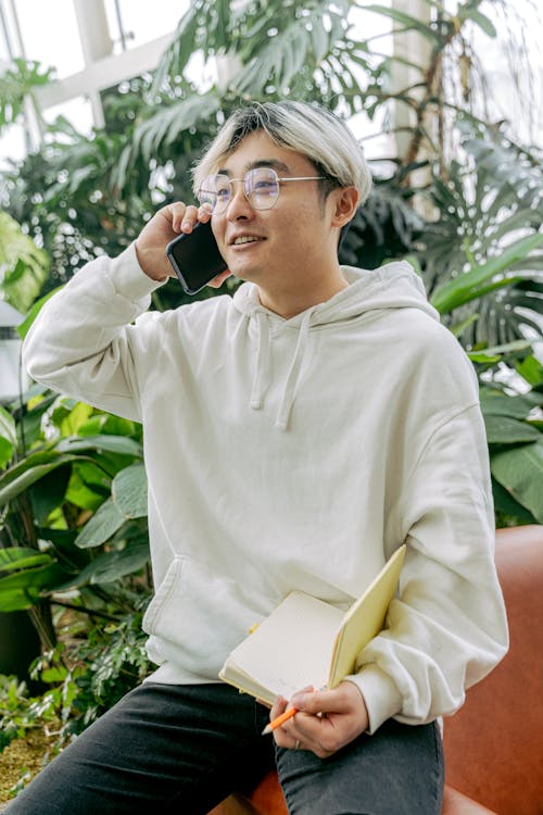 Free Man in White Hoodie Talking on the Phone Stock Photo