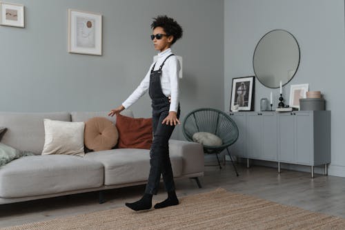 A Girl in White Turtleneck Sweater Walking Near the Couch