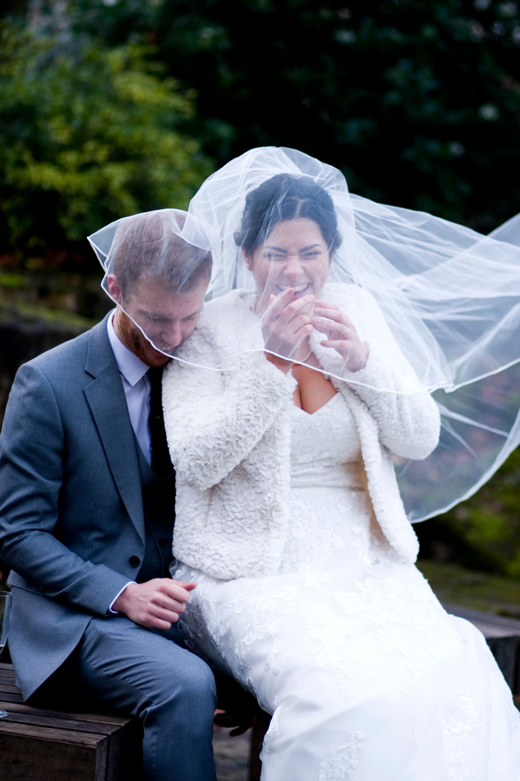 A joyful candid moment beneath a wedding veil
