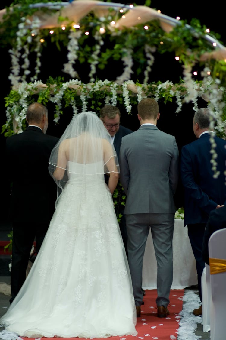 Bride And Groom Standing In Front Of A Wedding Minister