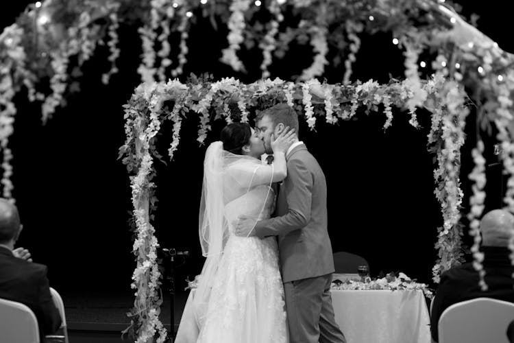 Bride And Groom Kissing In Front Of The Altar At The Ceremony 