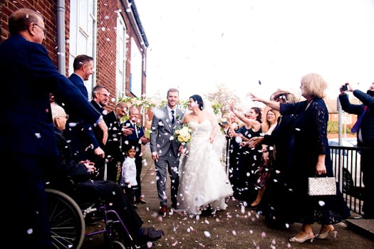 Bride and groom surrounded by guests throwing confetti, celebrating their wedding day.
