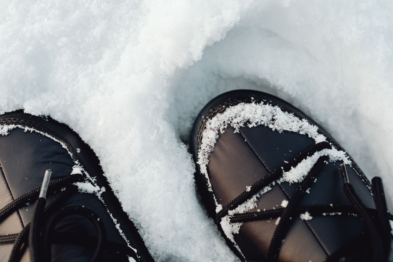 black winter boots covered in fresh snow