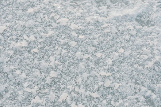 Close-up shot of intricate snowflakes on a frozen surface, showcasing winter beauty.