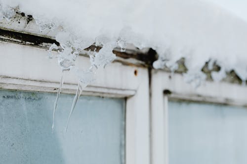 Close-up of Little Icicles and Snow Above a Window 