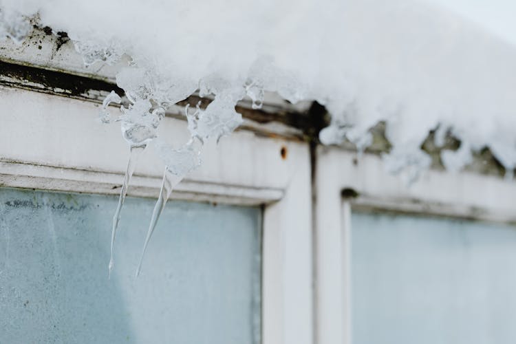 Close-up Of Little Icicles And Snow Above A Window 