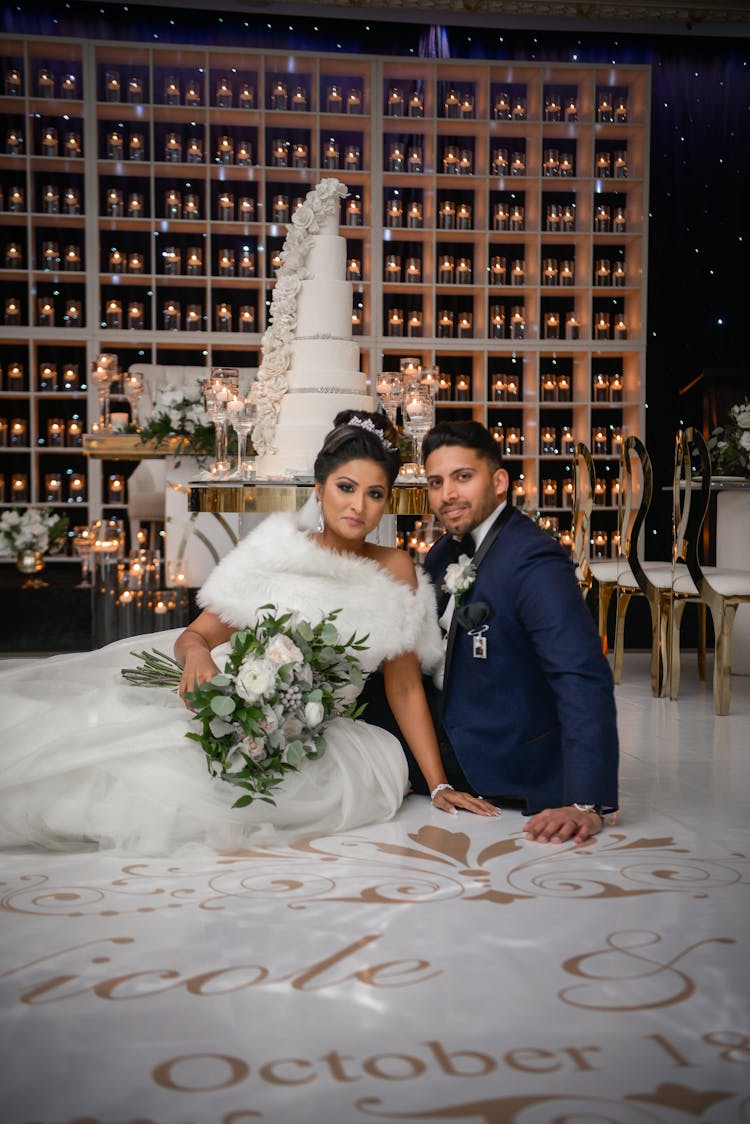 Man And Woman Sitting On The Floor Near A Wedding Cake