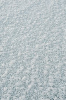 Close-up view of frosty snow texture, capturing the intricate natural patterns in winter.