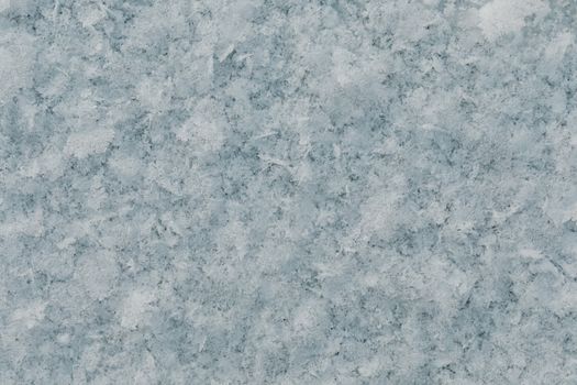 Close-up view of frosty snowflakes forming a textured ice surface.