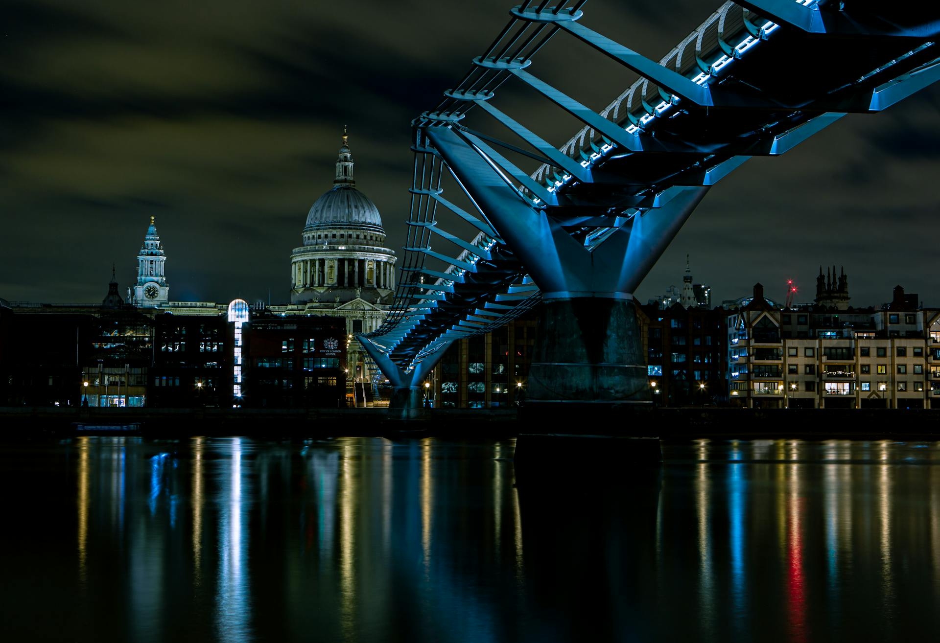 Night view of the Millennium Bridge with St. Paul's Cathedral reflection in the Thames River.