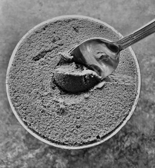 Close Up Black and White Photo of Spoon in Ice Cream