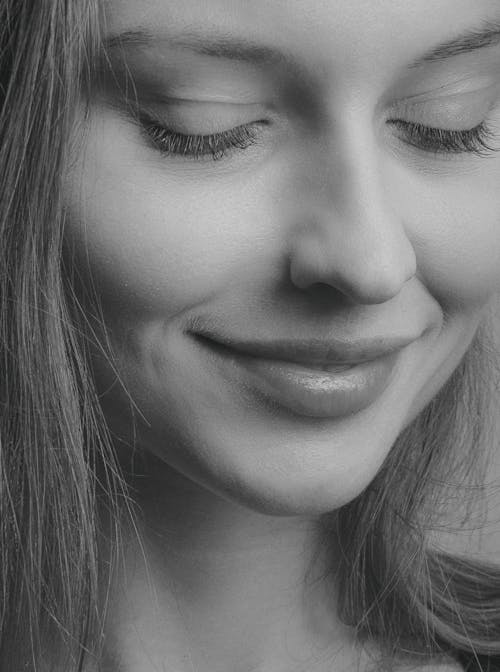 A Woman with Eyes Closed in Grayscale Photography