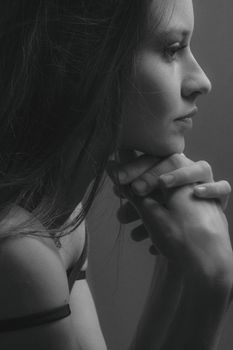 Side profile portrait of a woman in grayscale, emphasizing emotion and depth.