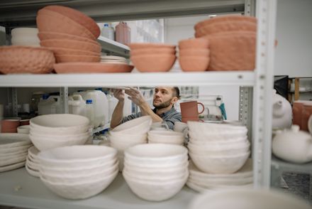 Potter arranging finished bowls on a studio shelf — photo by Yan Krukau on Pexels