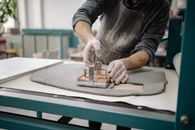 A Person Cutting a Flattened Raw Clay Pot