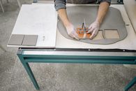 A Person Holding a Stainless Tool on a Flattened Clay