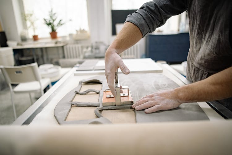 Worker Cutting Out Tiles From Clay