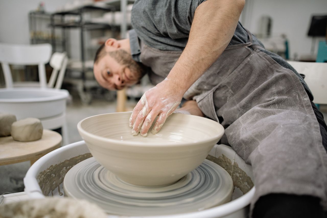skilled potter shaping clay on a pottery wheel in an artisan studio sh