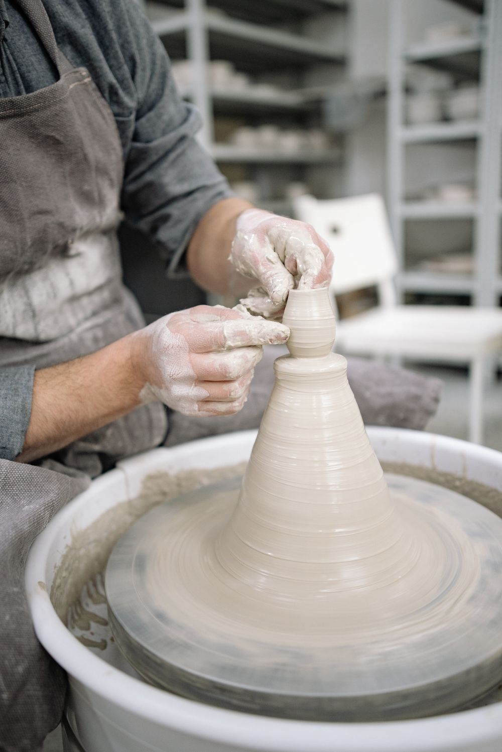 Potter shaping clay on the wheel