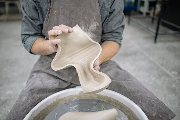 Person Creating Clay Pottery