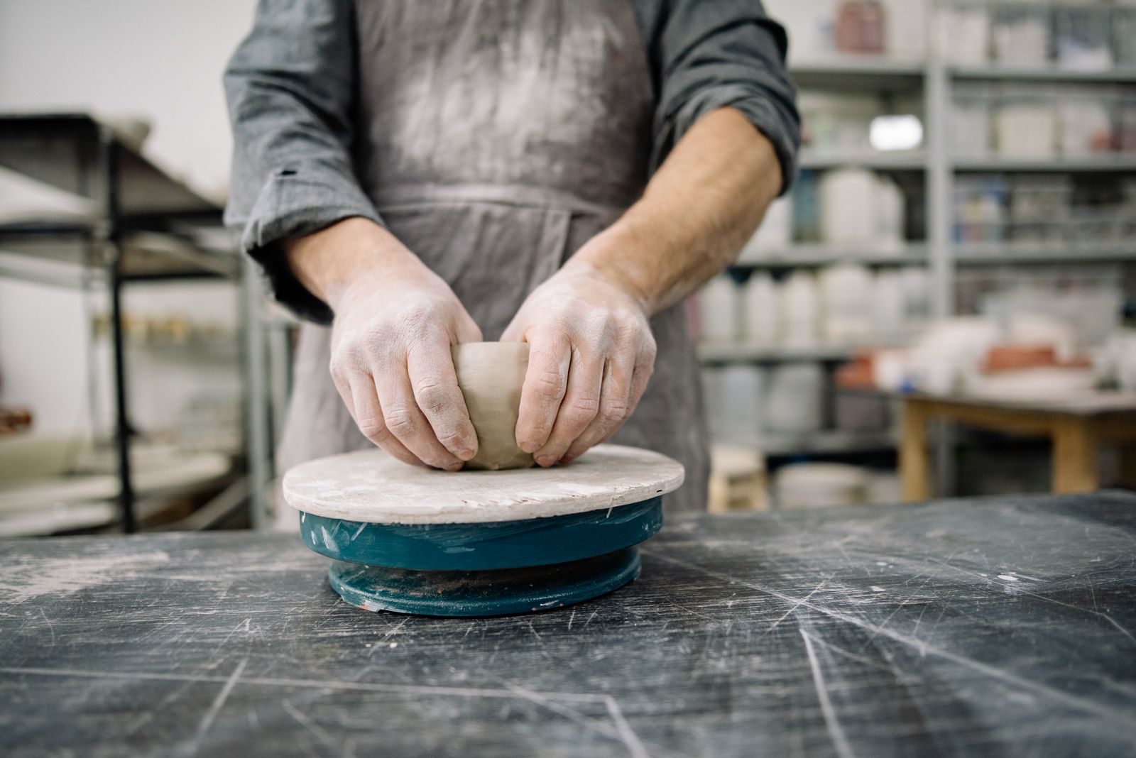 Hands shaping a clay form