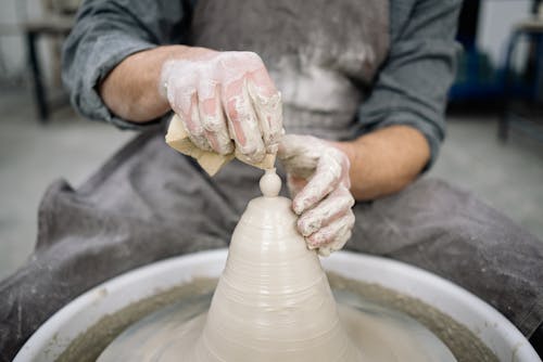 Photo of a Person Forming the Tip of a Clay Object