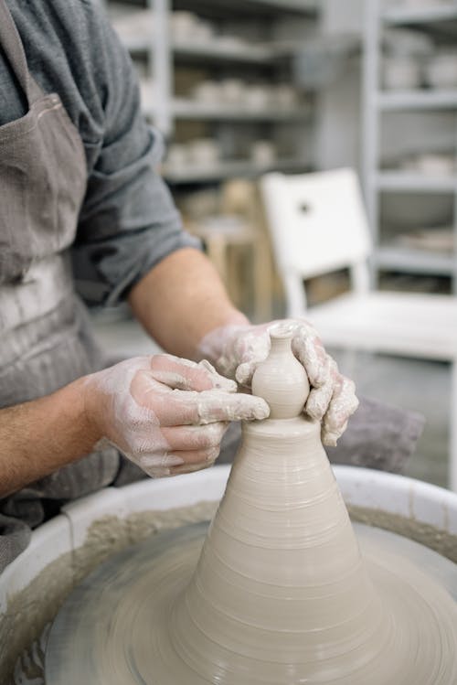 Photo of a Person's Hands Shaping Clay